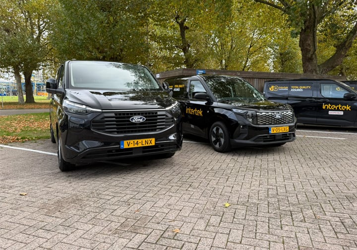 Three black vans with yellow Intertek branding. 