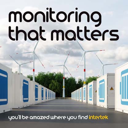 Battery containers with wind turbines in the background